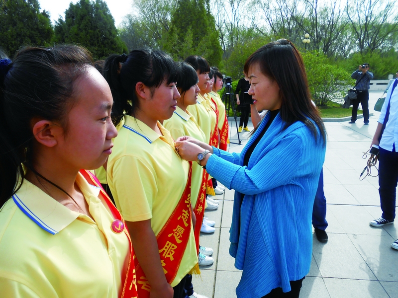 云玉美在呼和浩特市回民中学成人礼上为青少年佩戴徽章.jpg